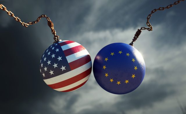 Wrecking balls textured with American and European Union flags over dark stormy sky. Horizontal composition with copy space and selective focus. Trade dispute concept.
