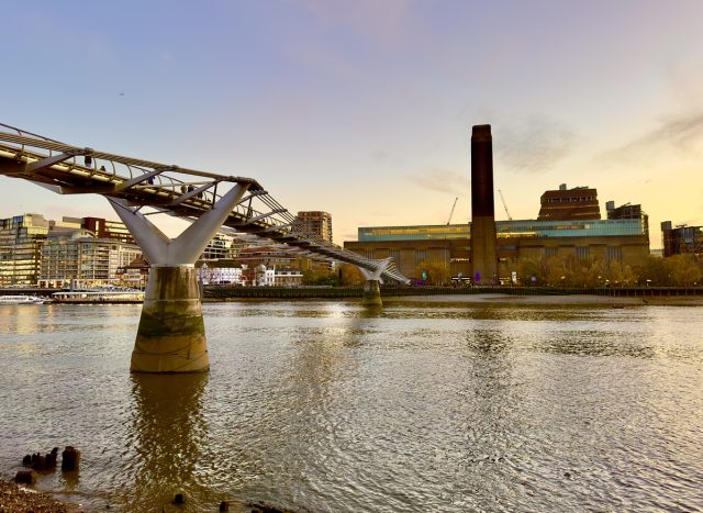 A twilight view of the Tate Modern Art Museum and the Millennium Bridge across the River Thames, London, UK.