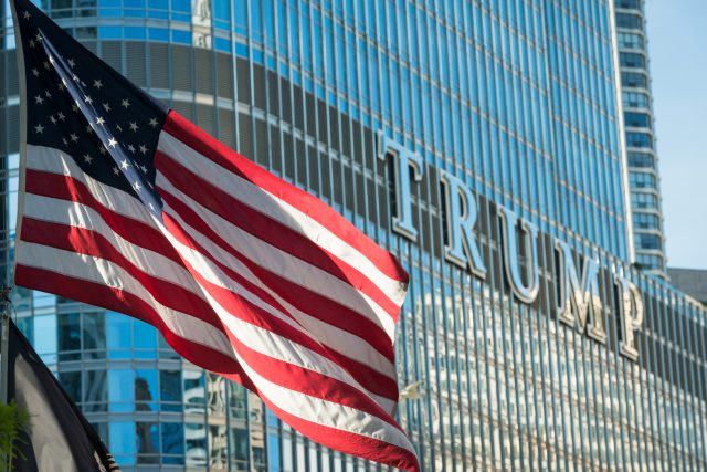 American flag flying on the Riverwalk with the Donald Trump Tower in the background.